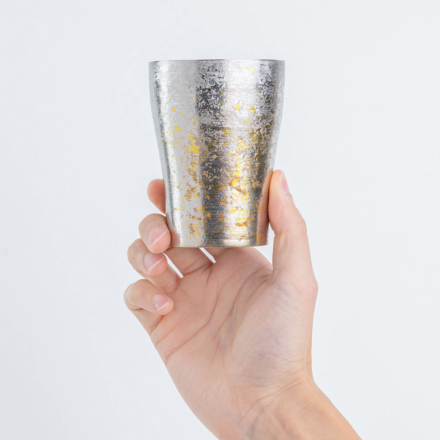 Hand holding the Taiko Series Silver Titanium Tumbler for size reference.