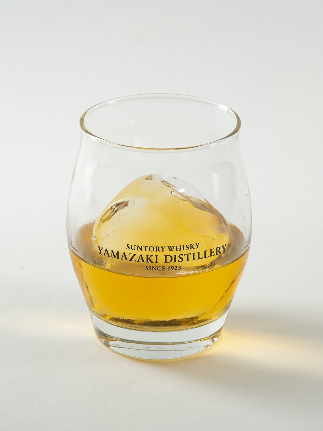Angled view of Yamazaki ice ball whiskey glass with whisky and ice