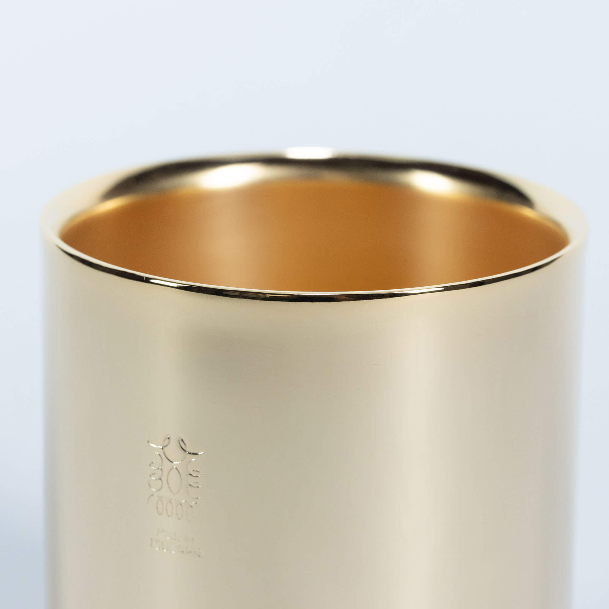 Close-up of the smooth rim and double-walled structure of the 24K gold-plated stainless steel coffee tumbler.