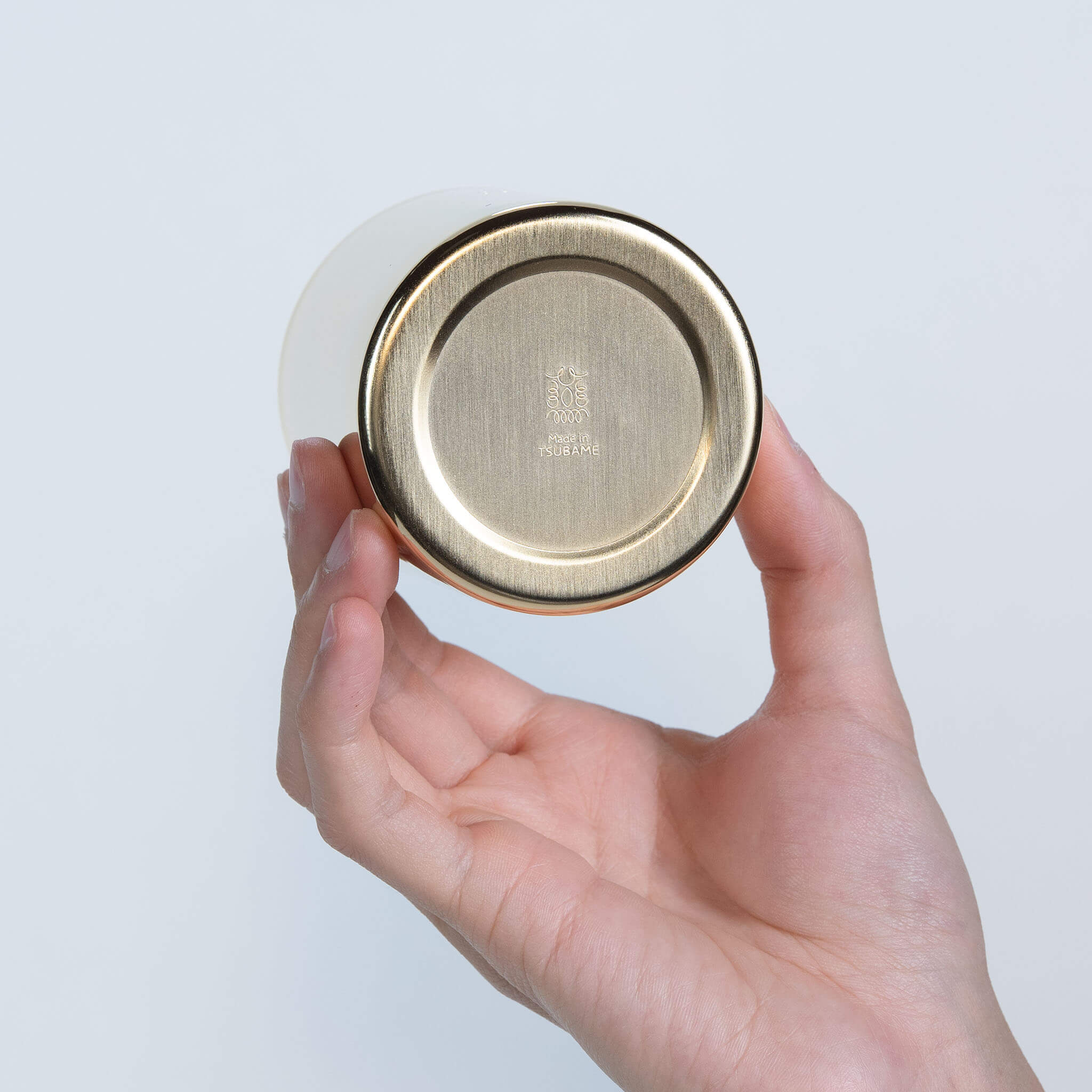 Bottom view of the gold-plated metal cup showing the official engraved quality mark, made in Japan.