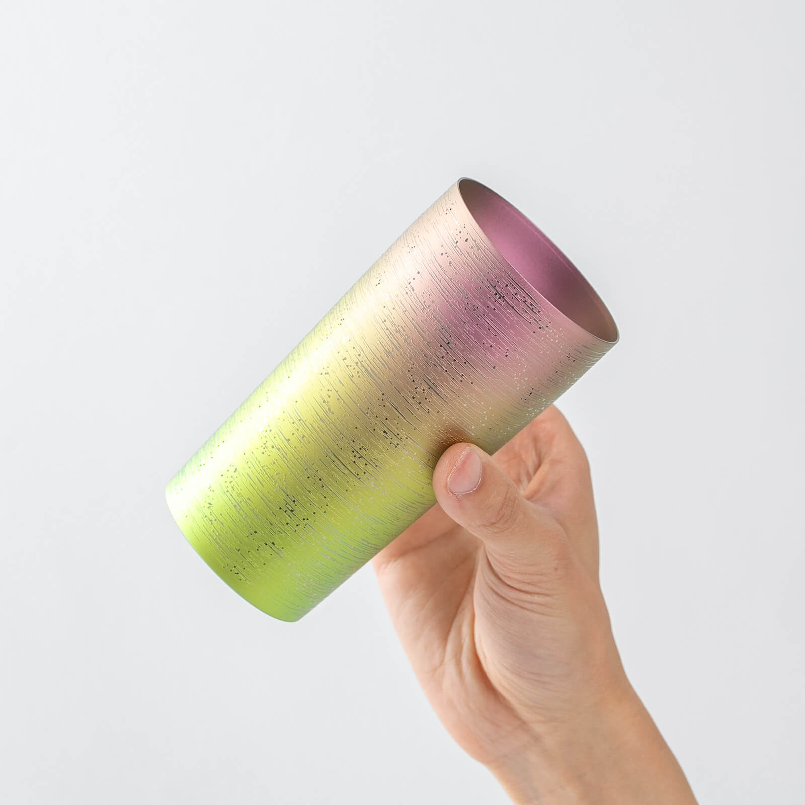 Hand tilting HORIE Ryo titanium tumbler to reveal purple-toned interior, fine surface texture helps produce richer beer foam