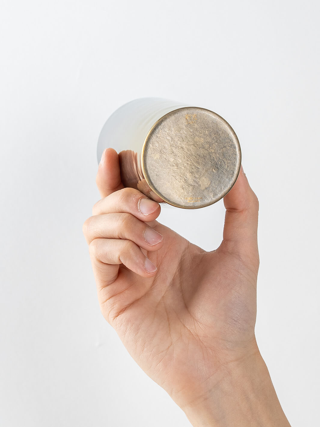 Bottom view of HORIE Saiko gold-silver titanium tumbler (350ml) held in hand