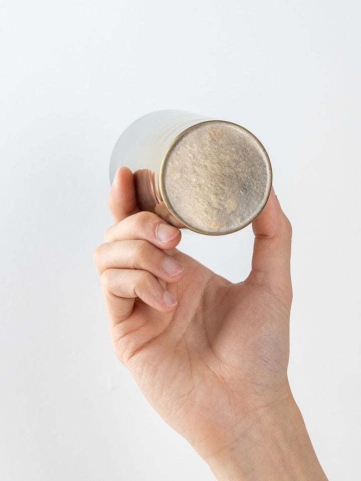 Bottom view of HORIE Saiko gold-silver titanium tumbler (350ml) held in hand