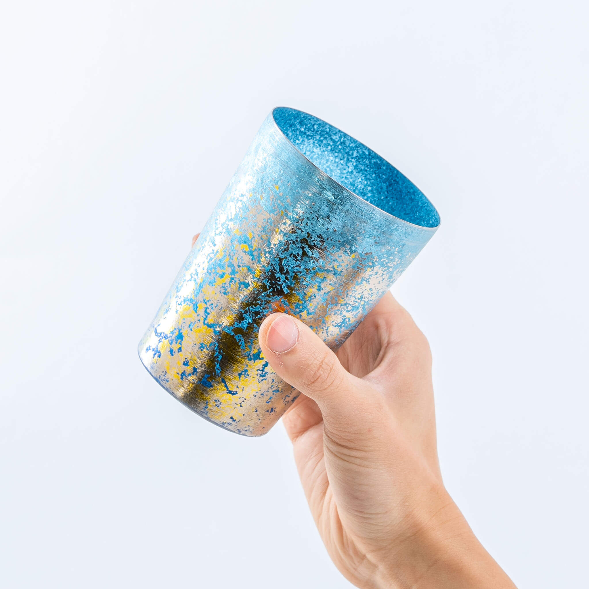 Side view of a hand holding the blue HORIE Taiko titanium tumbler