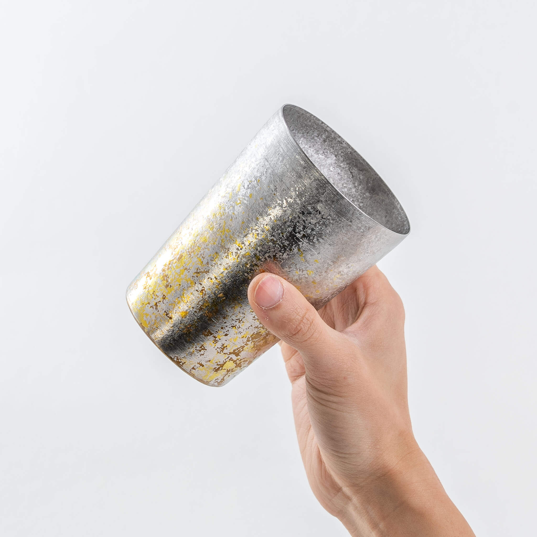 Side view of a hand holding the silver HORIE Taiko titanium tumbler