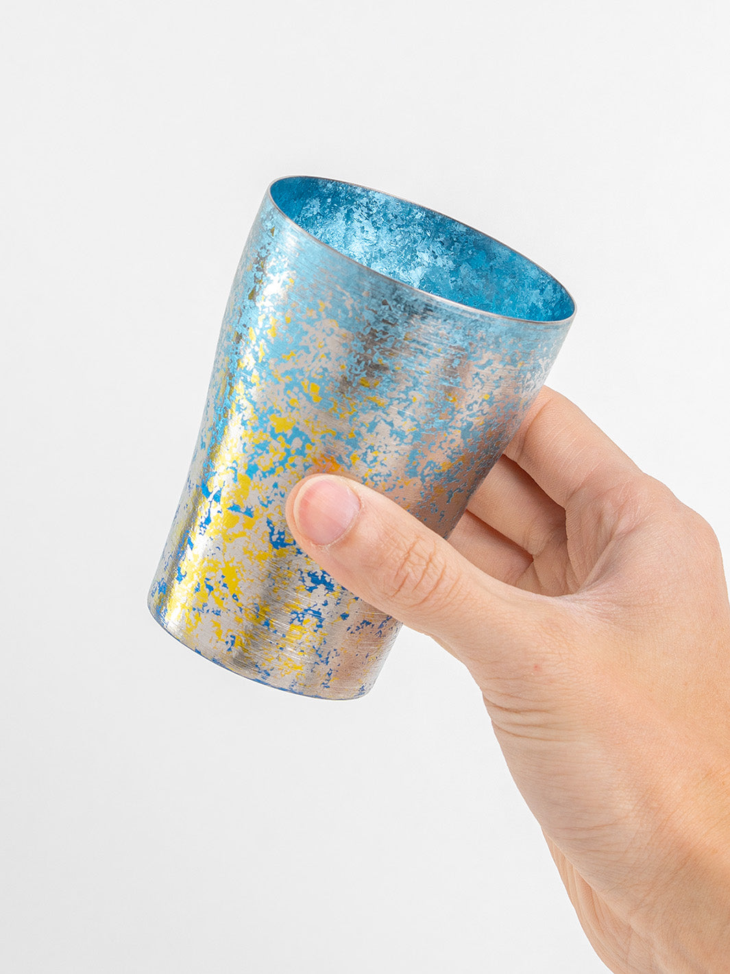 Side view of blue titanium tumbler in hand