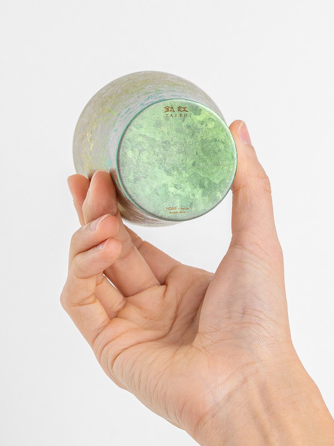 Bottom of pink titanium tumbler displayed in hand