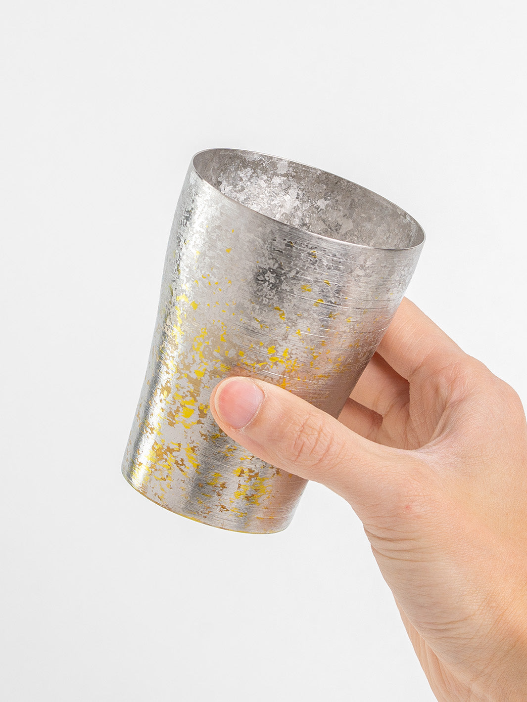 Side angle of silver tumbler held in hand