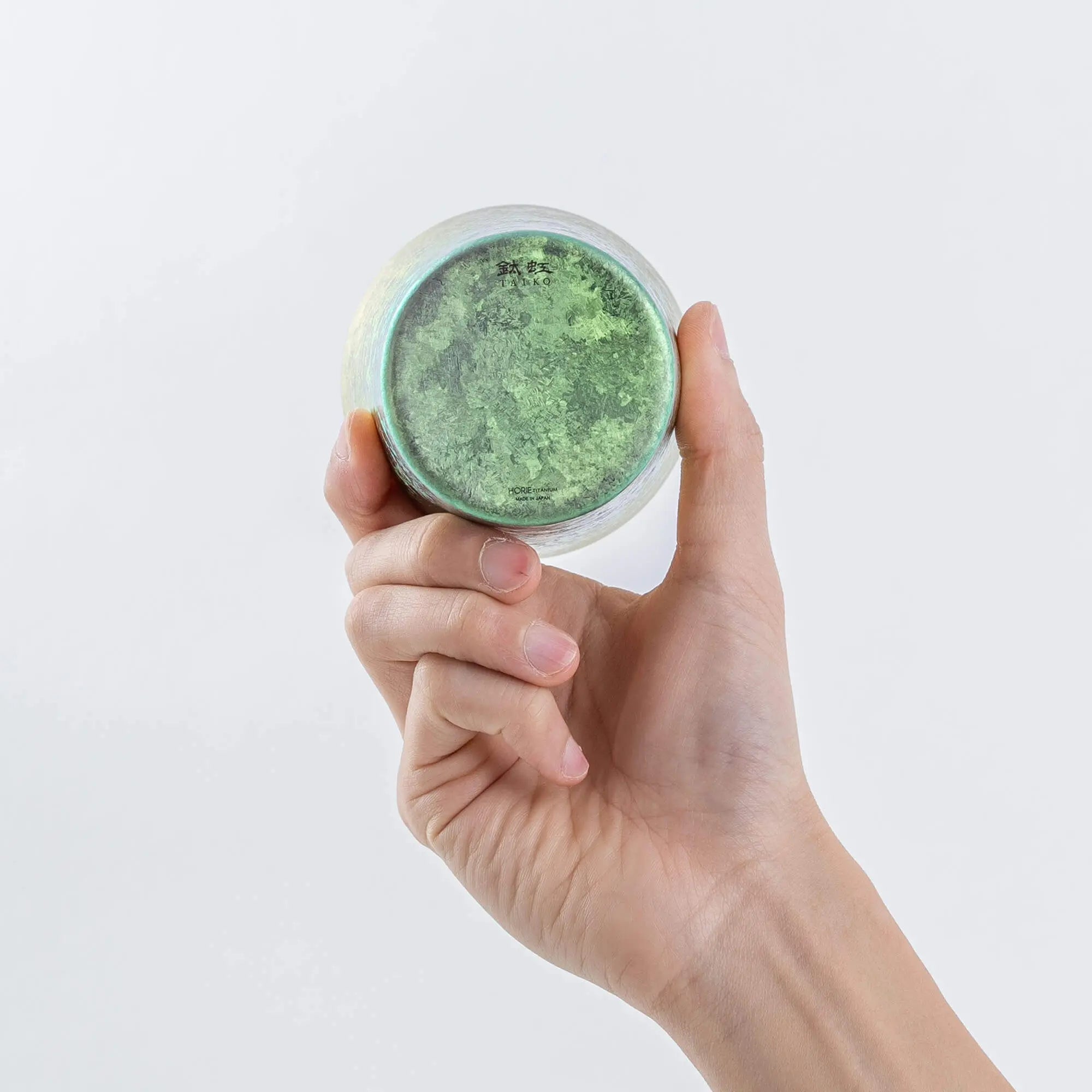 Hand showing bottom of pink titanium tumbler