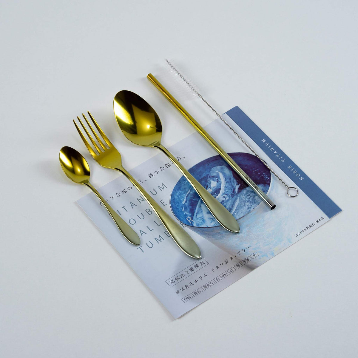 Gold HORIE pure titanium cutlery set arranged on a Japanese magazine
