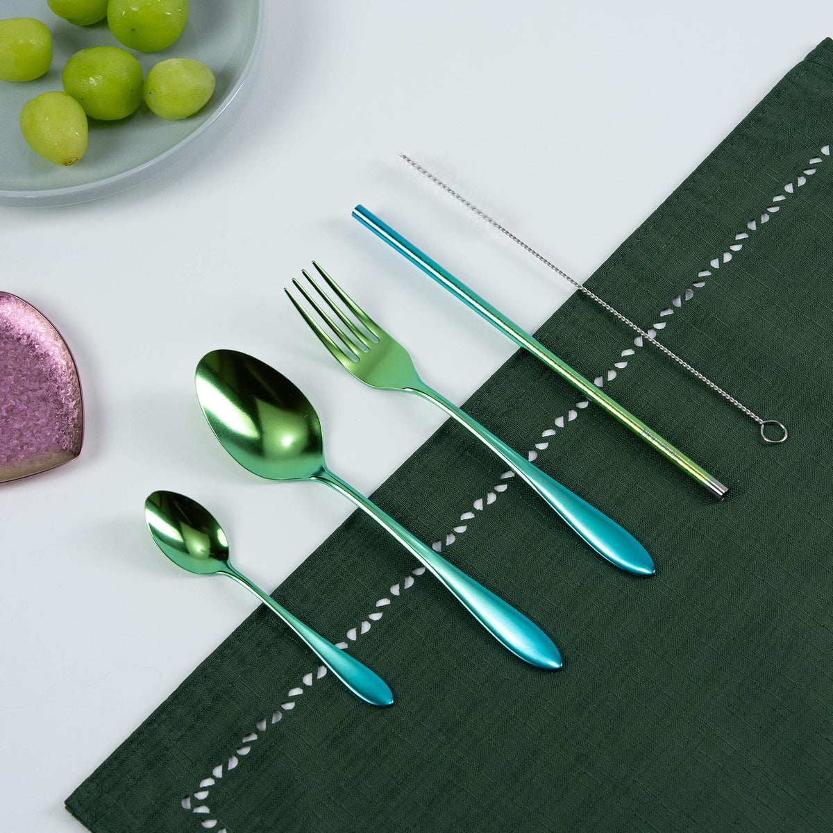 HORIE green-to-blue gradient titanium cutlery set arranged on a green tablecloth