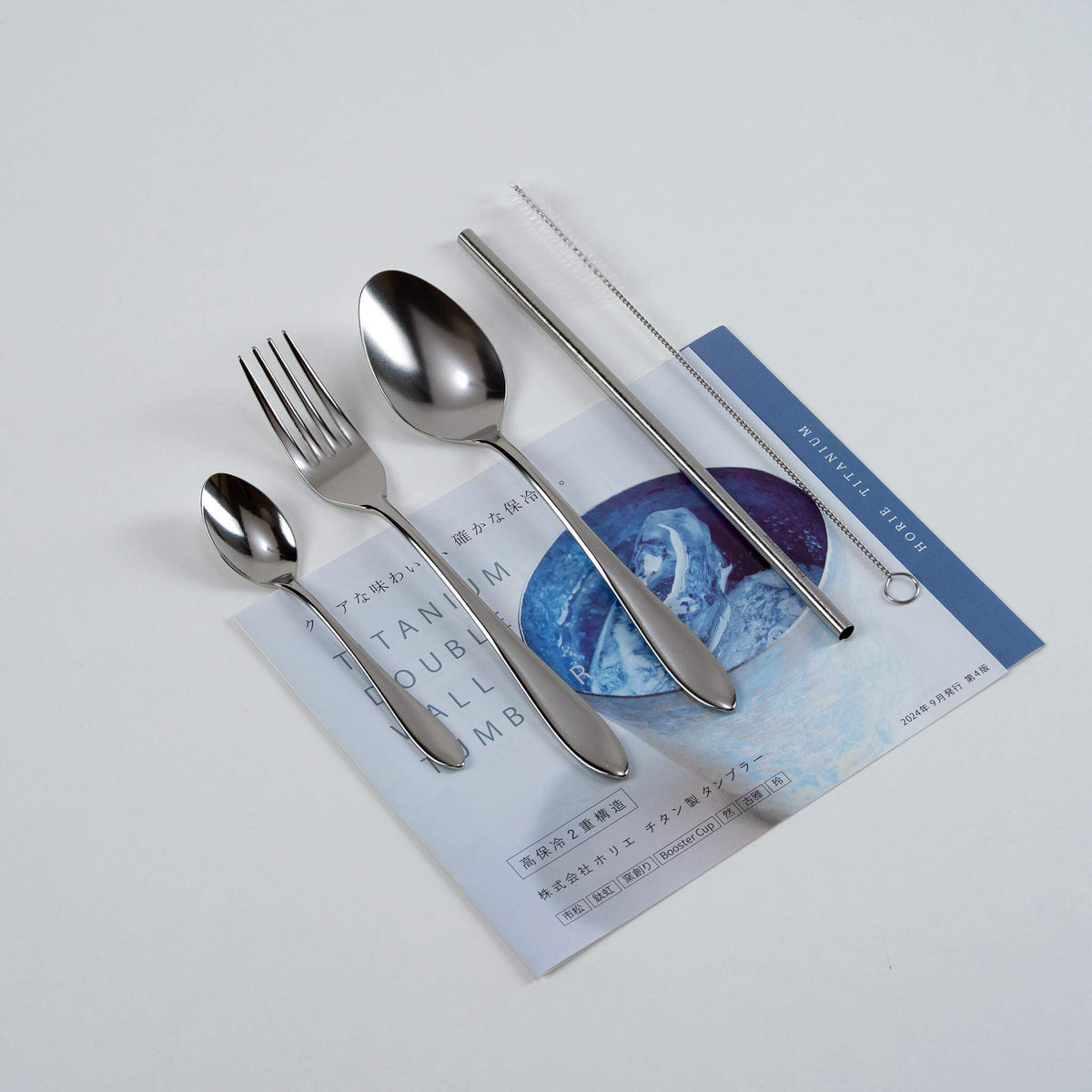 Natural silver HORIE pure titanium cutlery set arranged on a Japanese magazine
