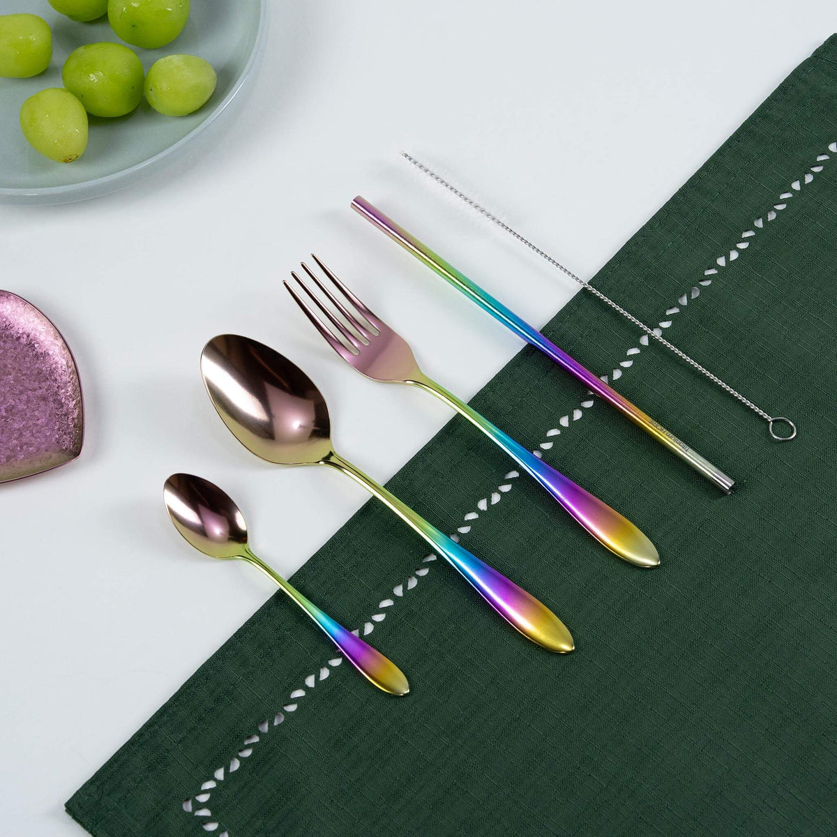 HORIE rainbow titanium cutlery set arranged on a green tablecloth