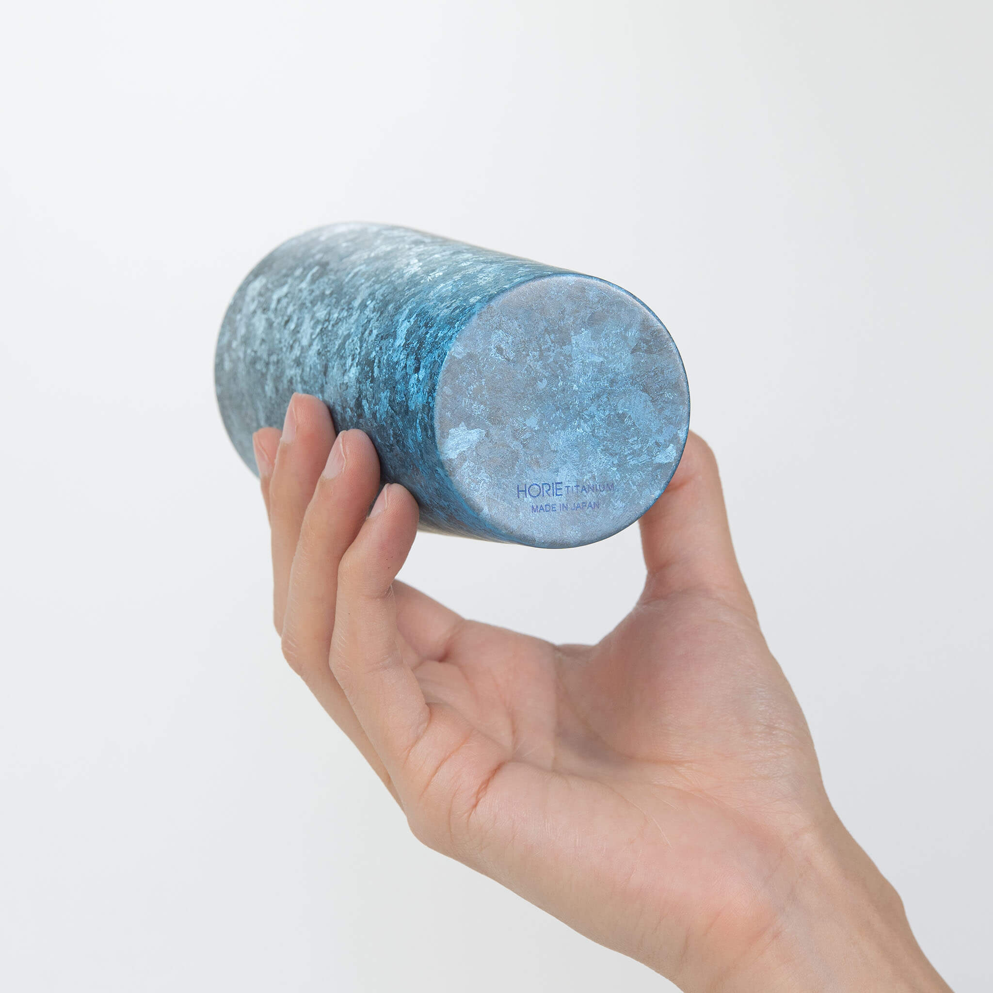 Hand holding HORIE Titanium Kamazukuri 350ml Blue Tumbler upside down revealing HORIE TITANIUM MADE IN JAPAN base mark 