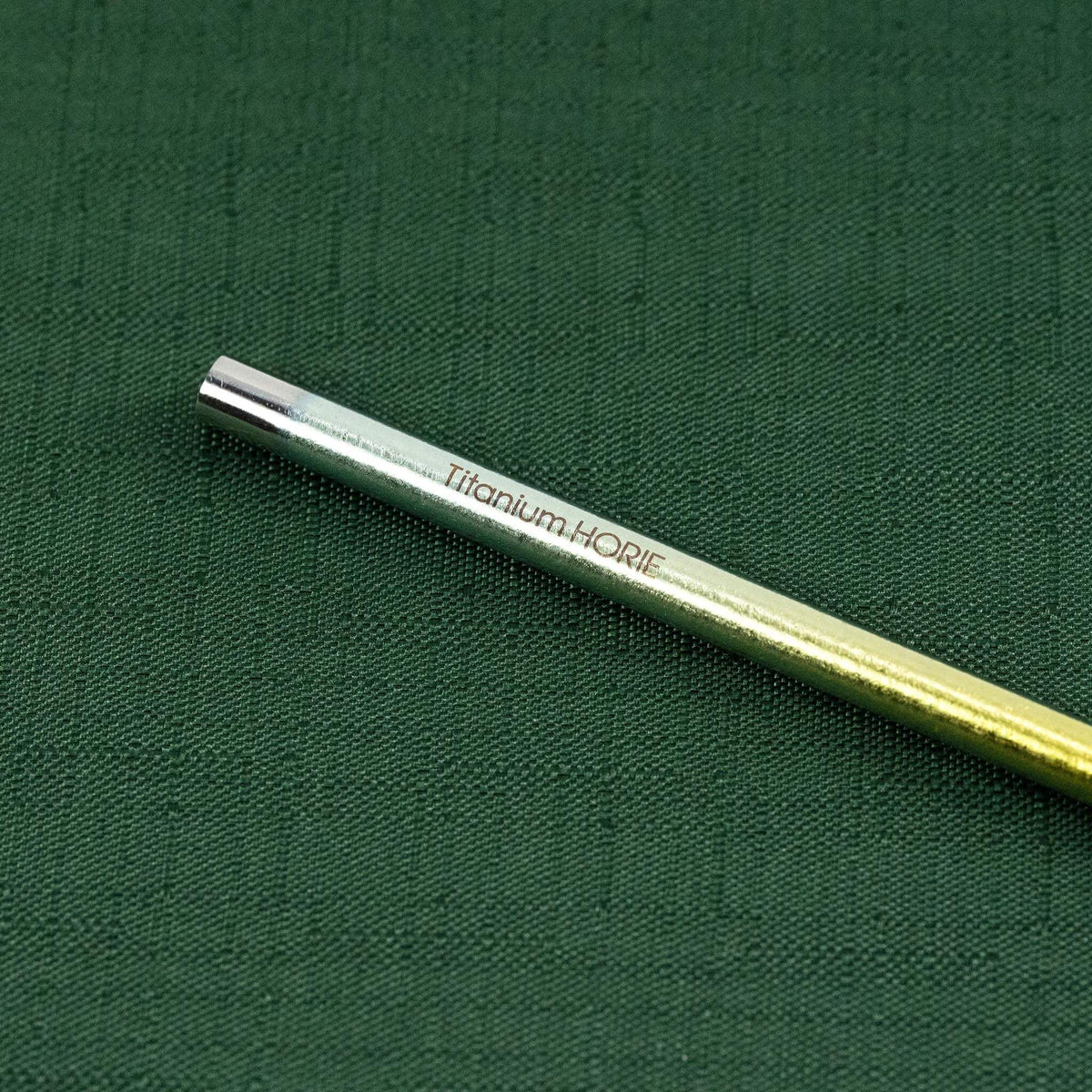 Close-up of the Titanium HORIE logo on the gold titanium straw