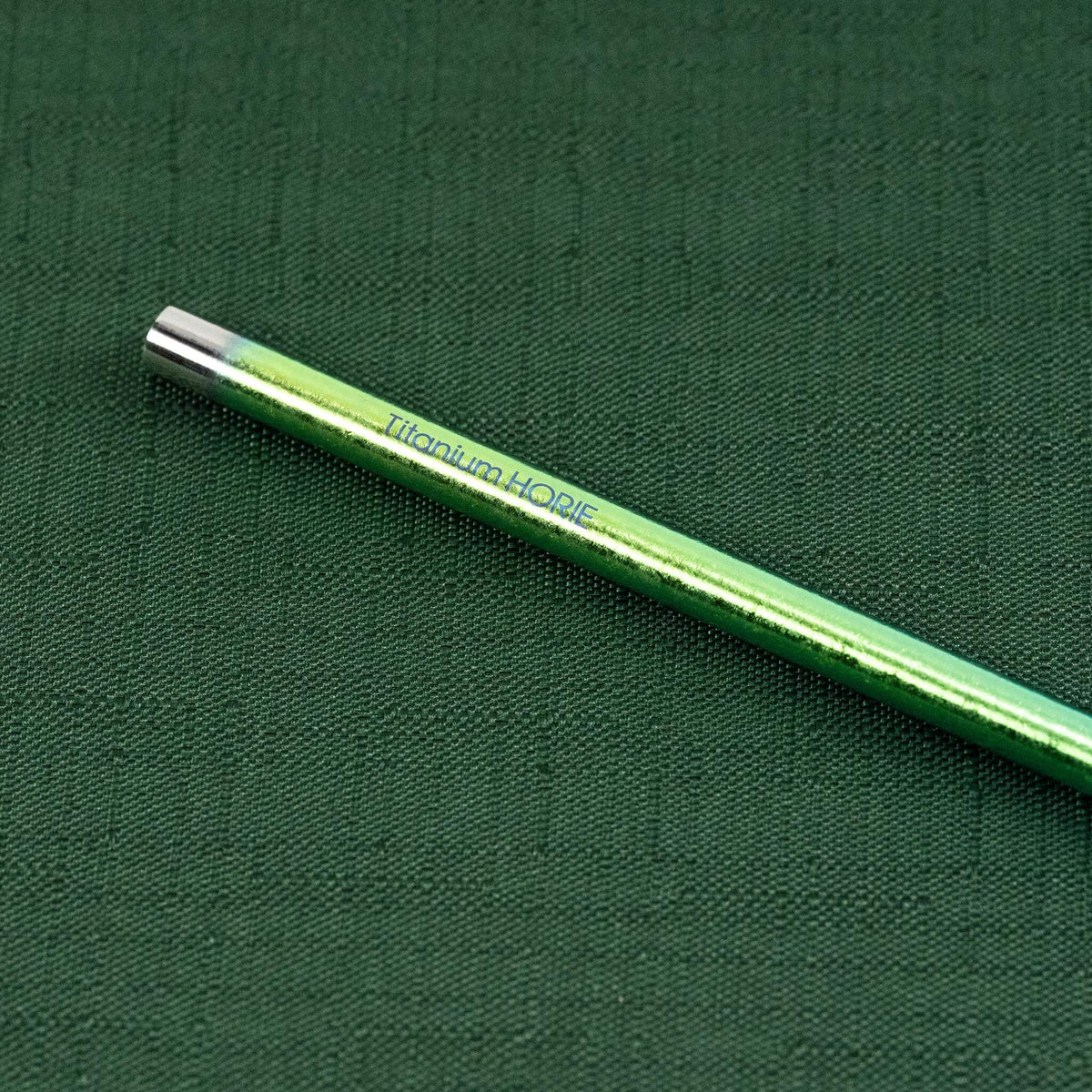 Close-up of the Titanium HORIE logo on the green gradient titanium straw
