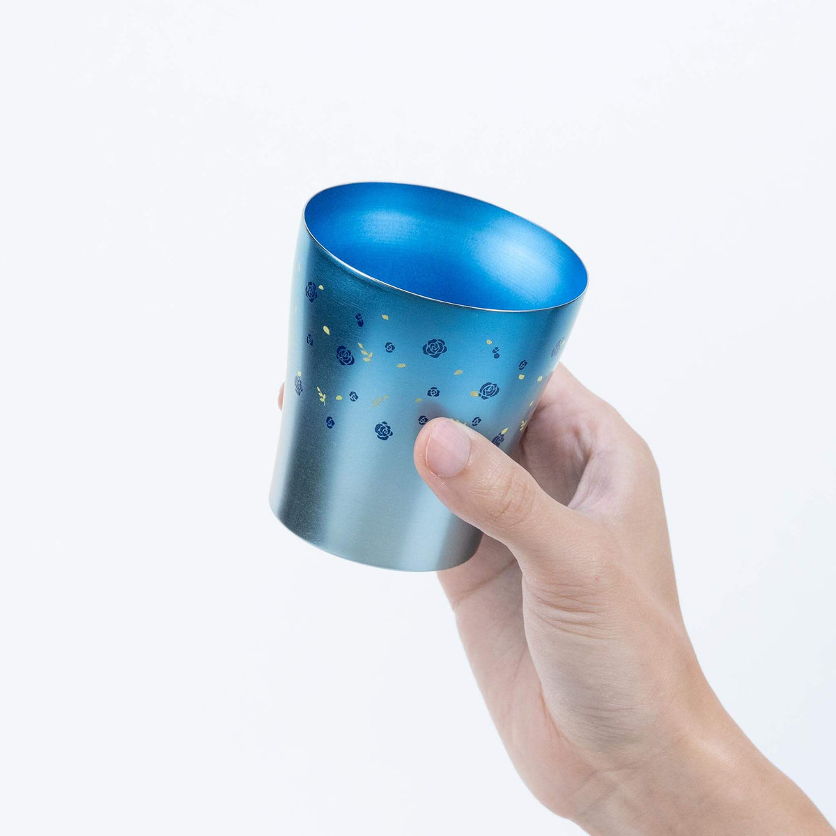 Side view of the blue HORIE Hana titanium tumbler held by hand