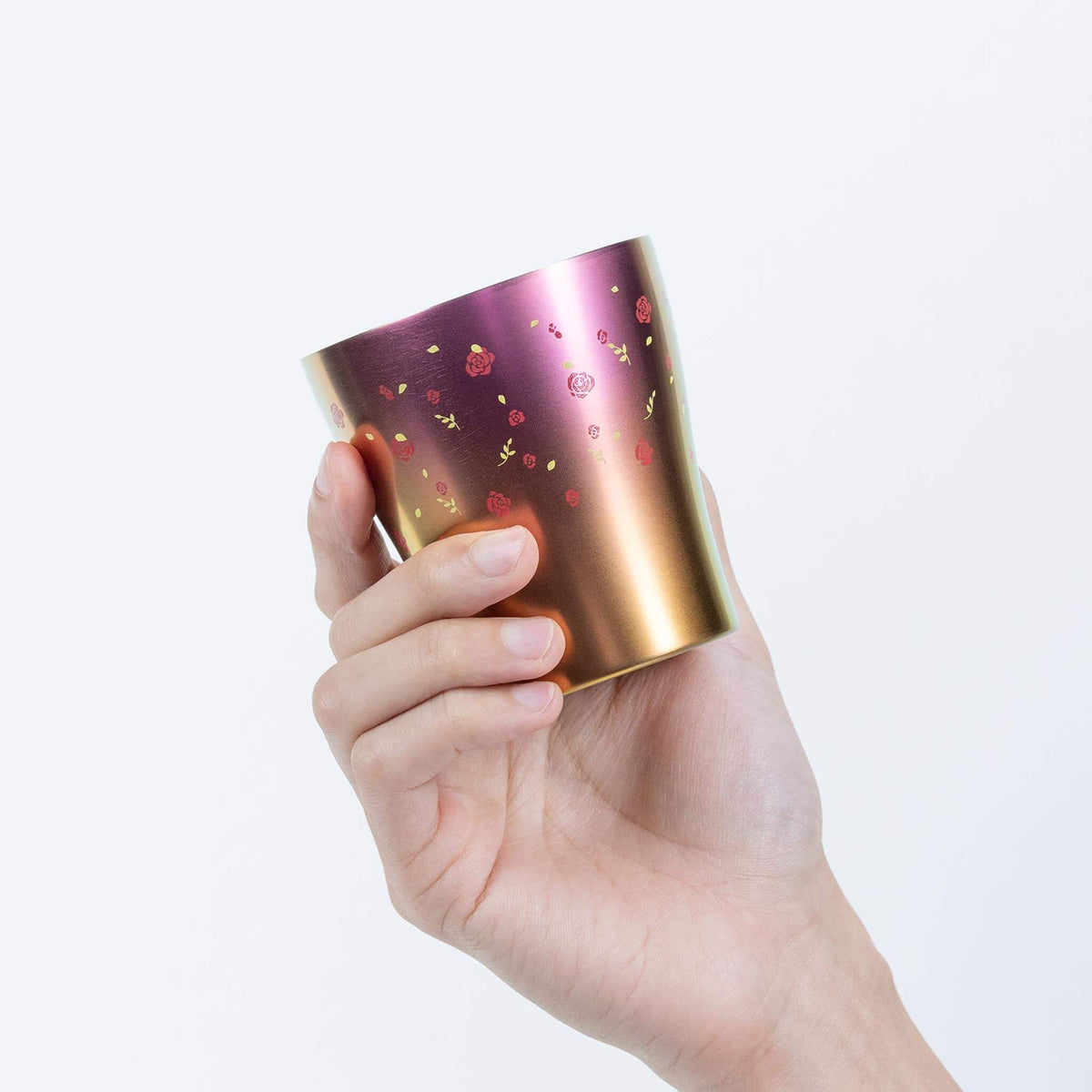 Side view of the pink HORIE Hana titanium tumbler held by hand