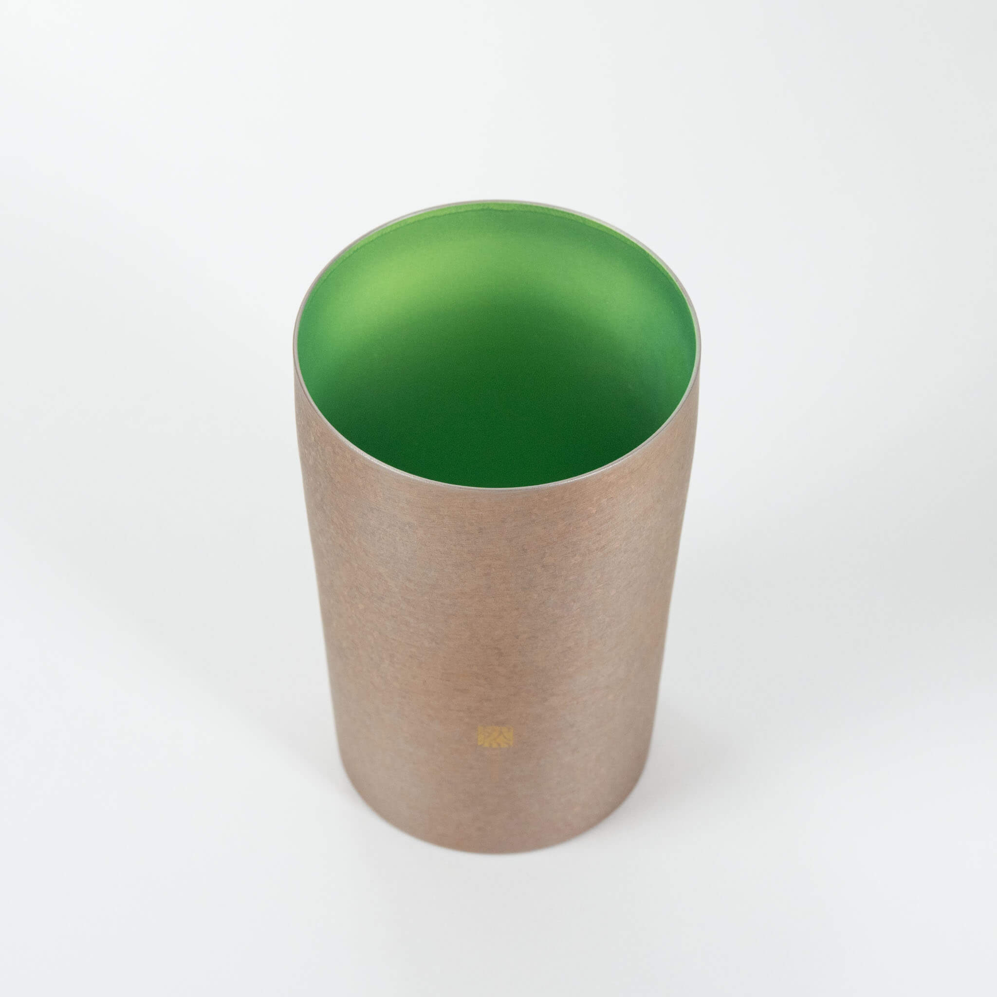 A high-angle view looking inside the Horie Zen titanium tumbler, highlighting the beautiful vivid green color achieved through advanced titanium anodization.