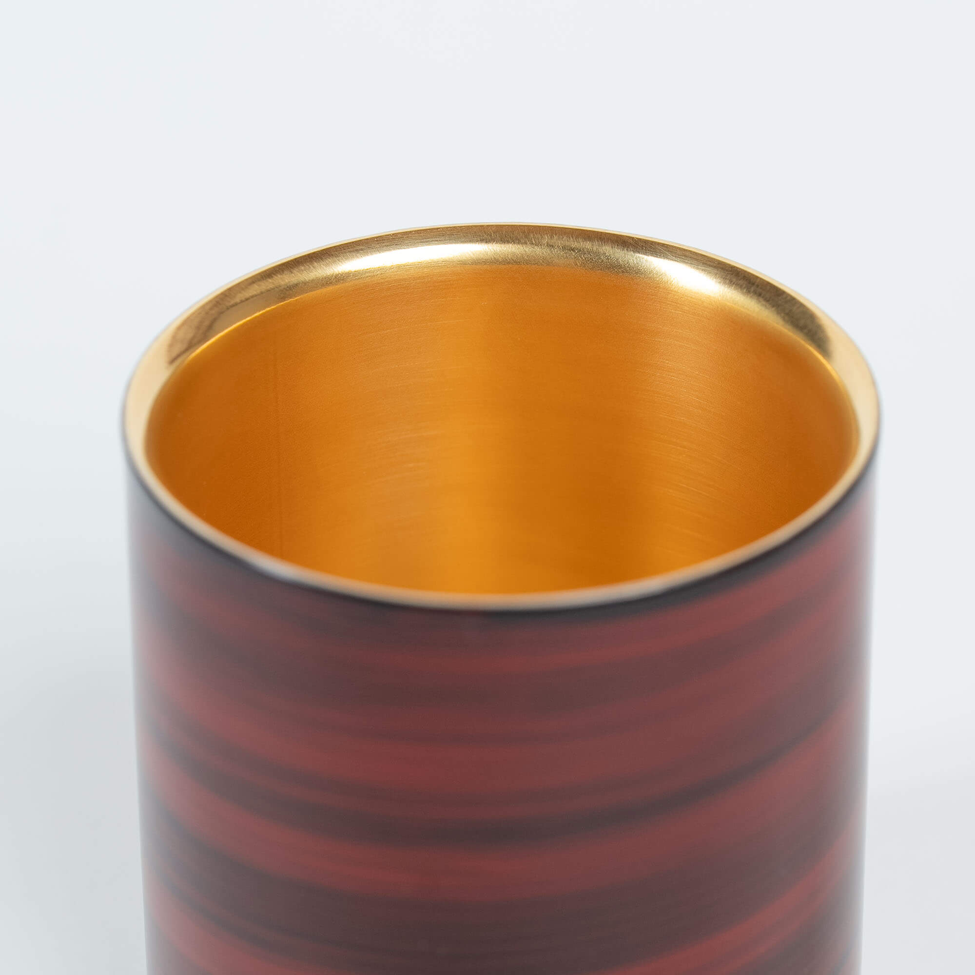 Close-up of the red striped lacquer finish on a Japanese stainless steel sake cup