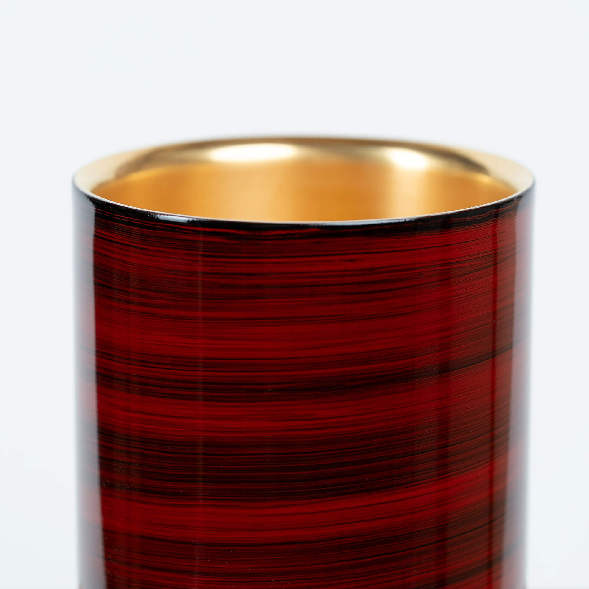 Close-up of the red striped lacquer finish on a Japanese stainless steel sake cup