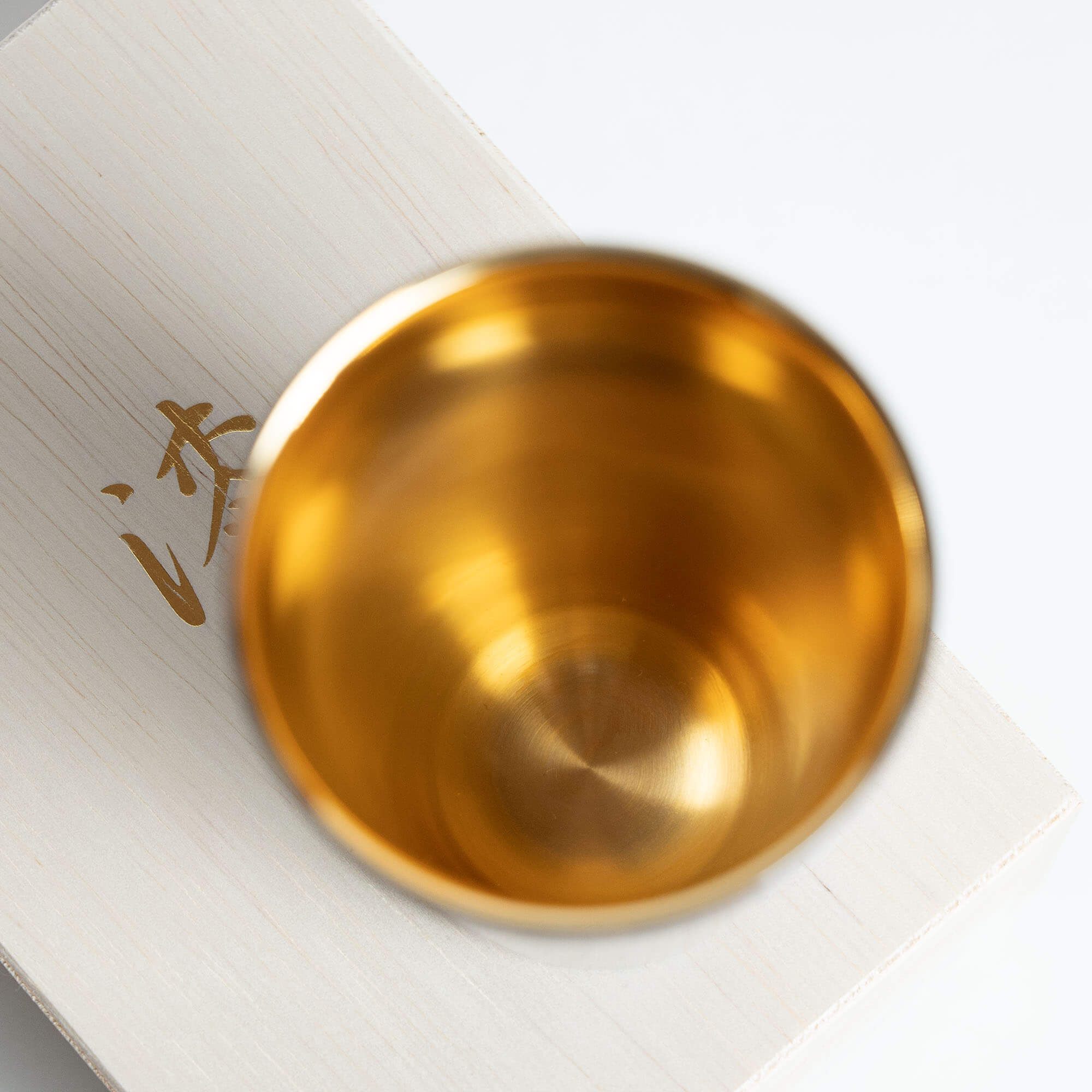 Close-up of the gold-plated interior of a red Japanese lacquered tumbler