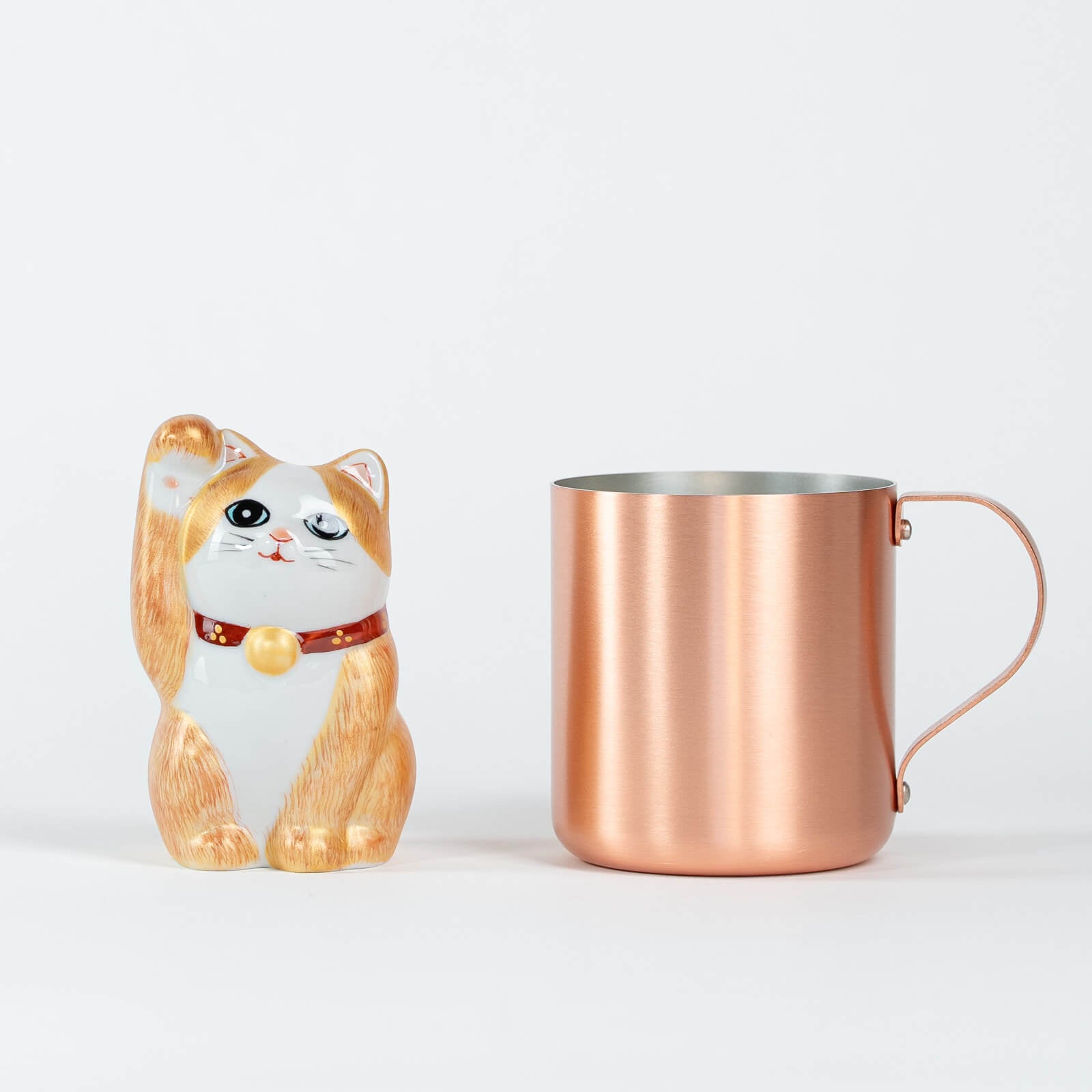 Size comparison of 10cm Kutani ceramic lucky cat with a mug.