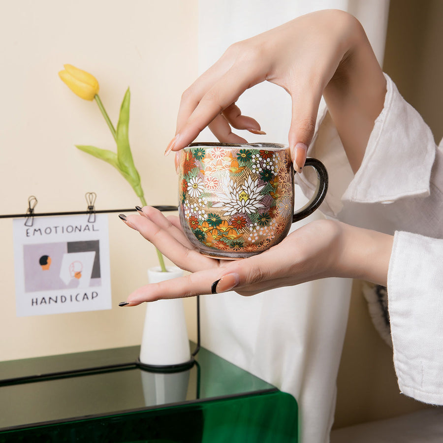 Hand holding a Kutani mug, side view.