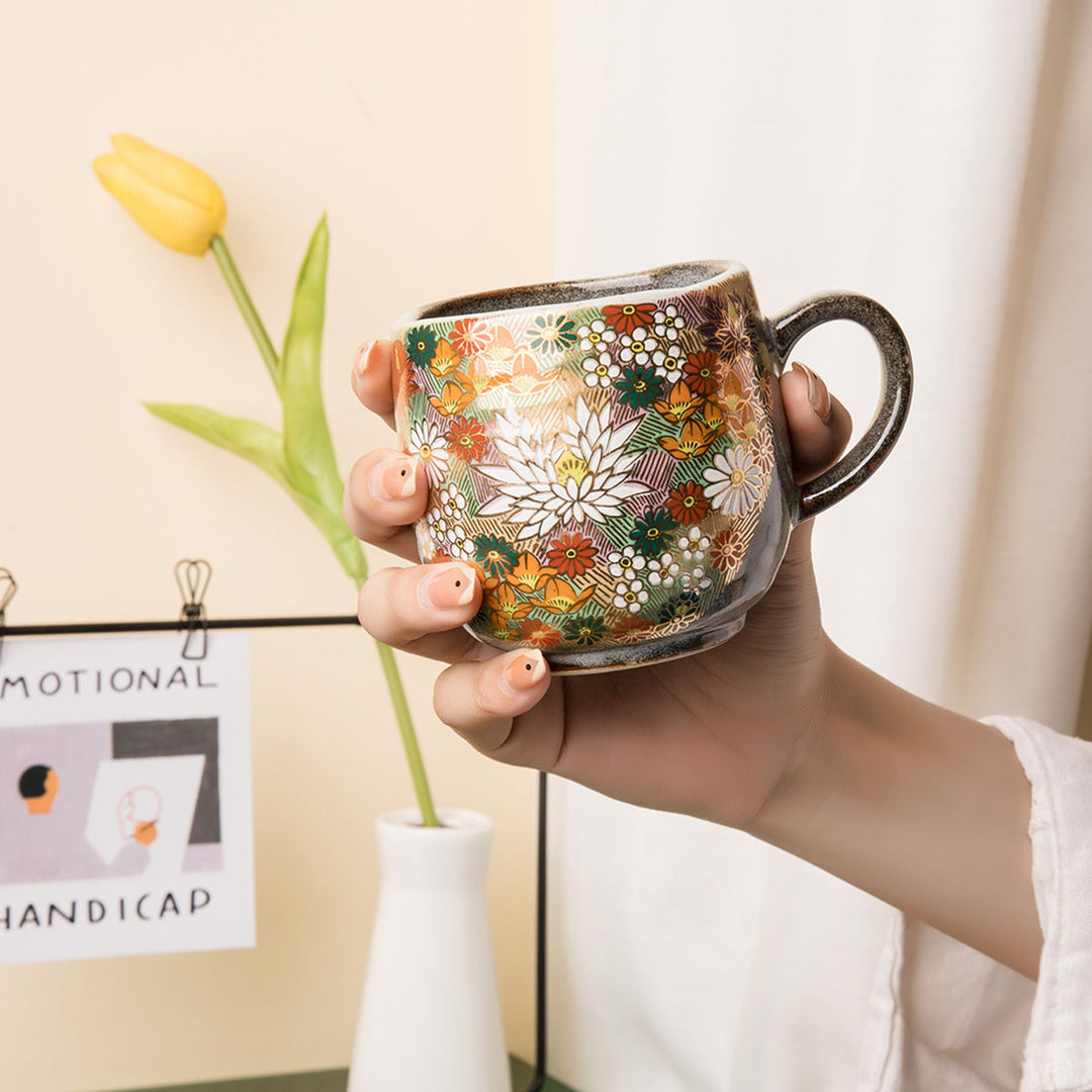 Hand holding a Kutani mug, top view.