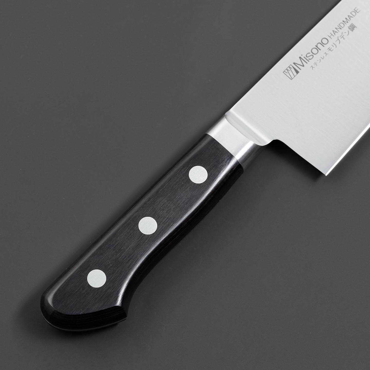 Close-up of the black handle, rivets and bolster on the Misono gyuto knife