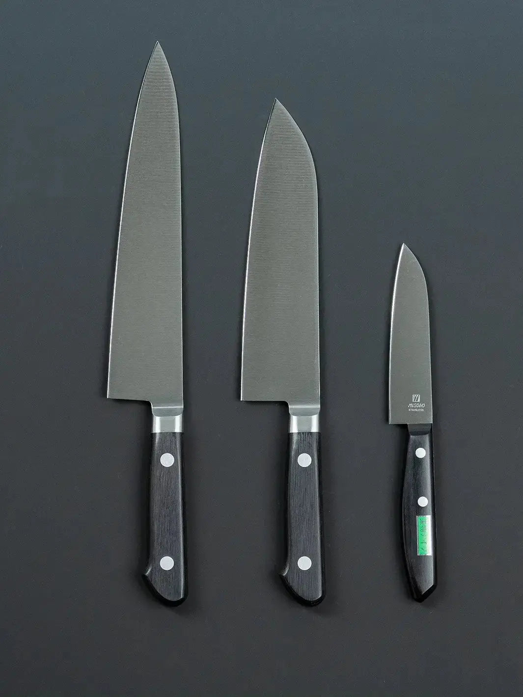Back view of the Misono gyuto, santoku, and petty knives, showing the handle design and any back-side details.