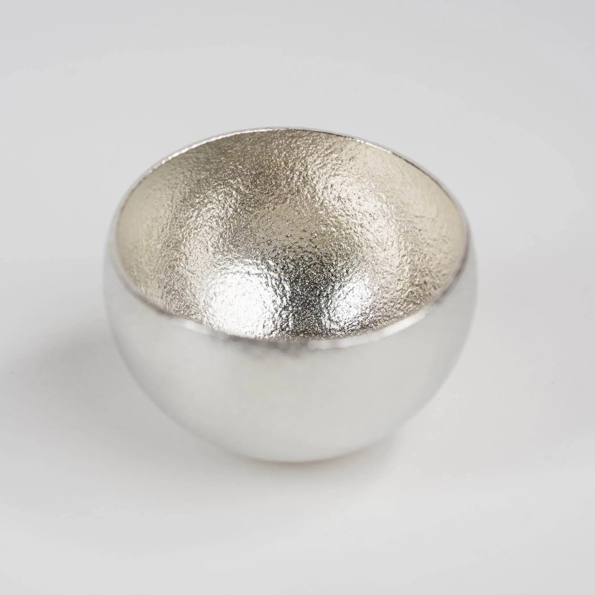 Close-up of the minimalist pure tin rim, highlighting the artisanal casting texture.