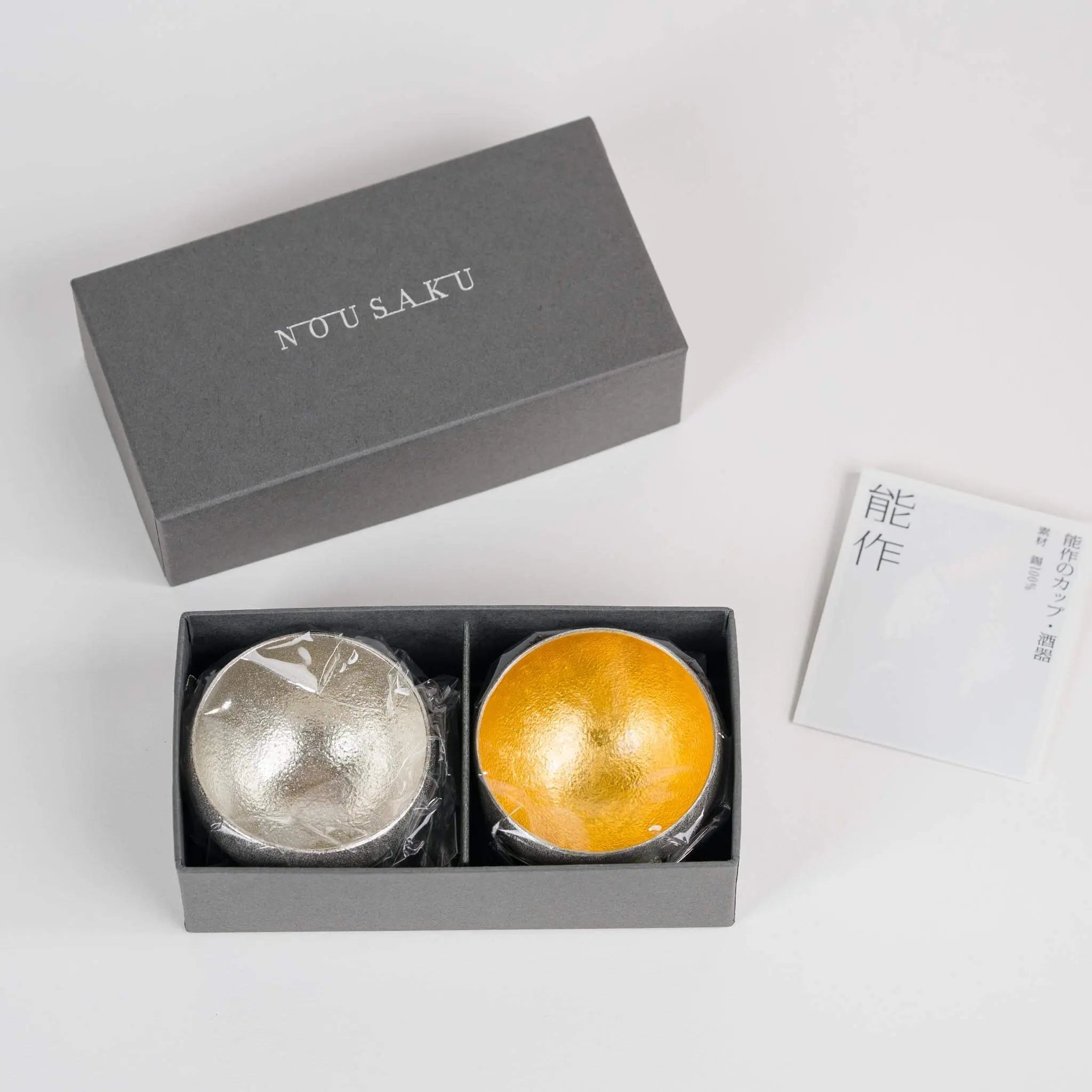 Top view of the Nousaku rocking sake cup set neatly arranged inside the elegant grey gift box.