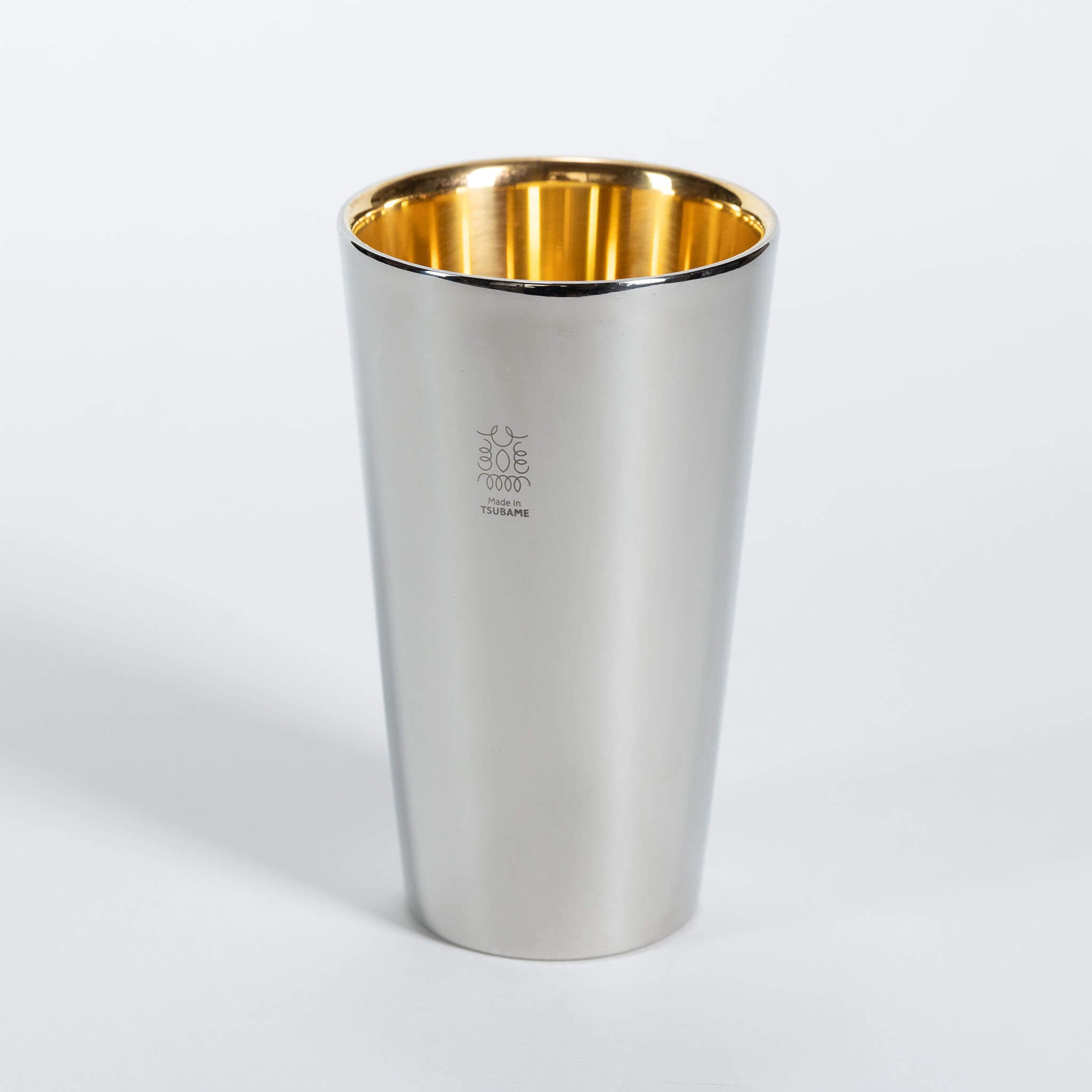 Sleek linear designed double-walled stainless steel beer tumbler with a brilliant gold-lined interior.
