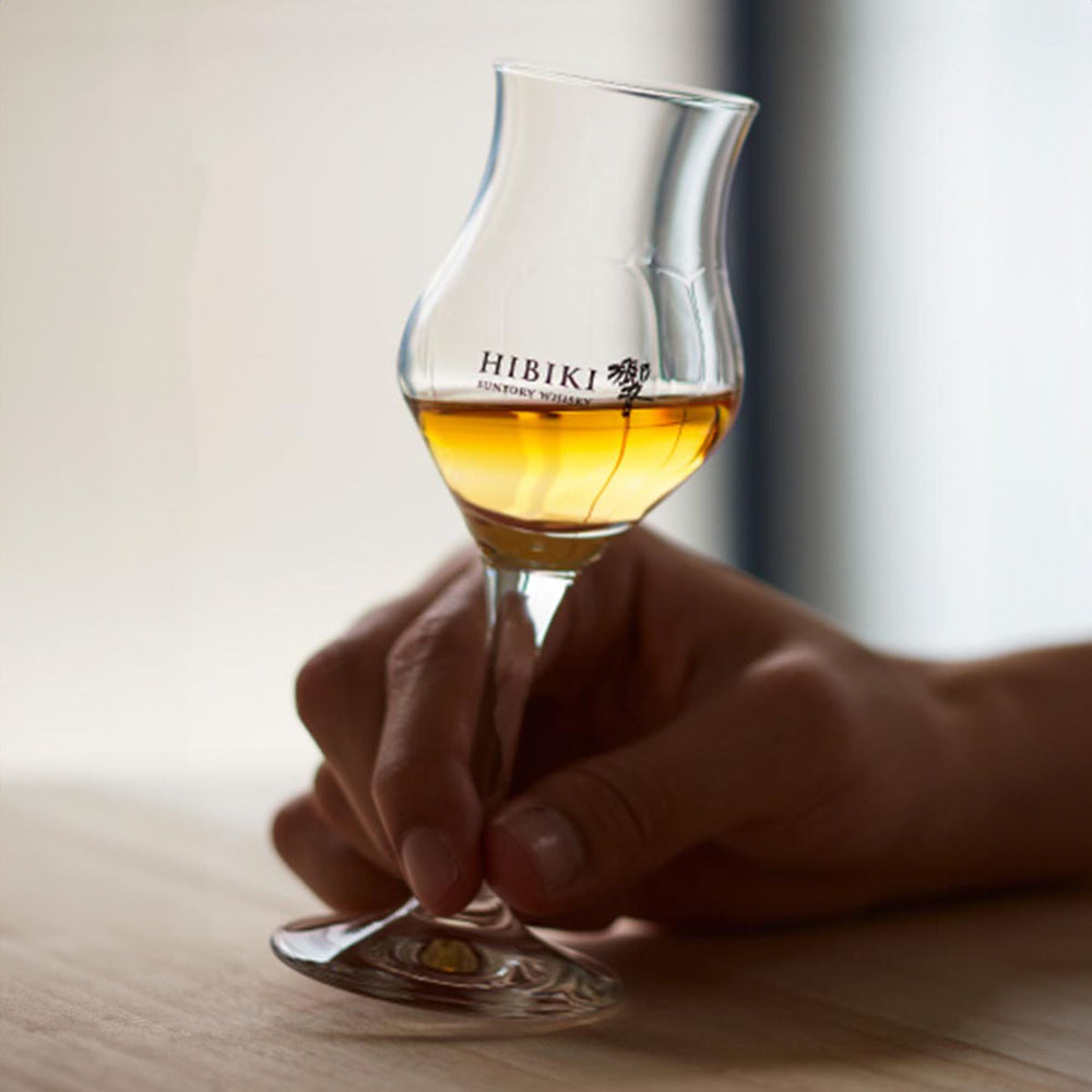 Hand holding the Suntory Hibiki Tasting Glass - 105ml, demonstrating the glass’s comfortable grip and size.