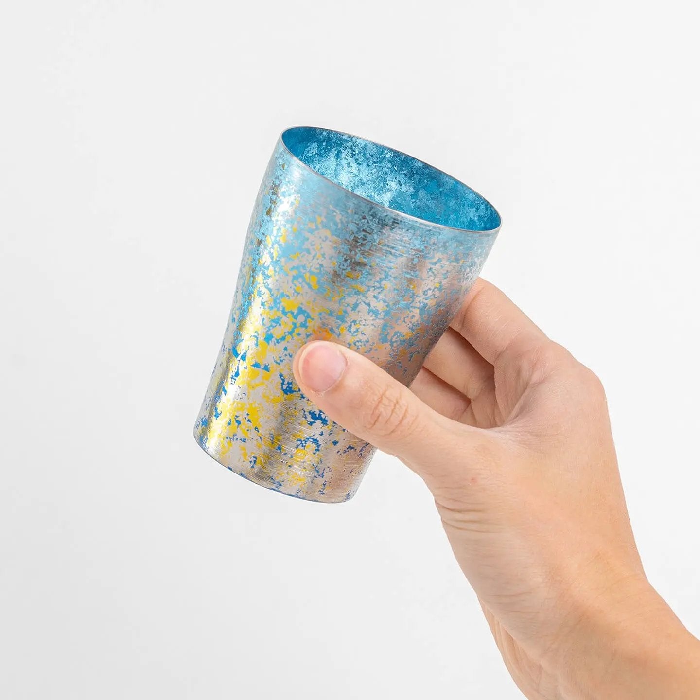 Hand holding blue HORIE tumbler