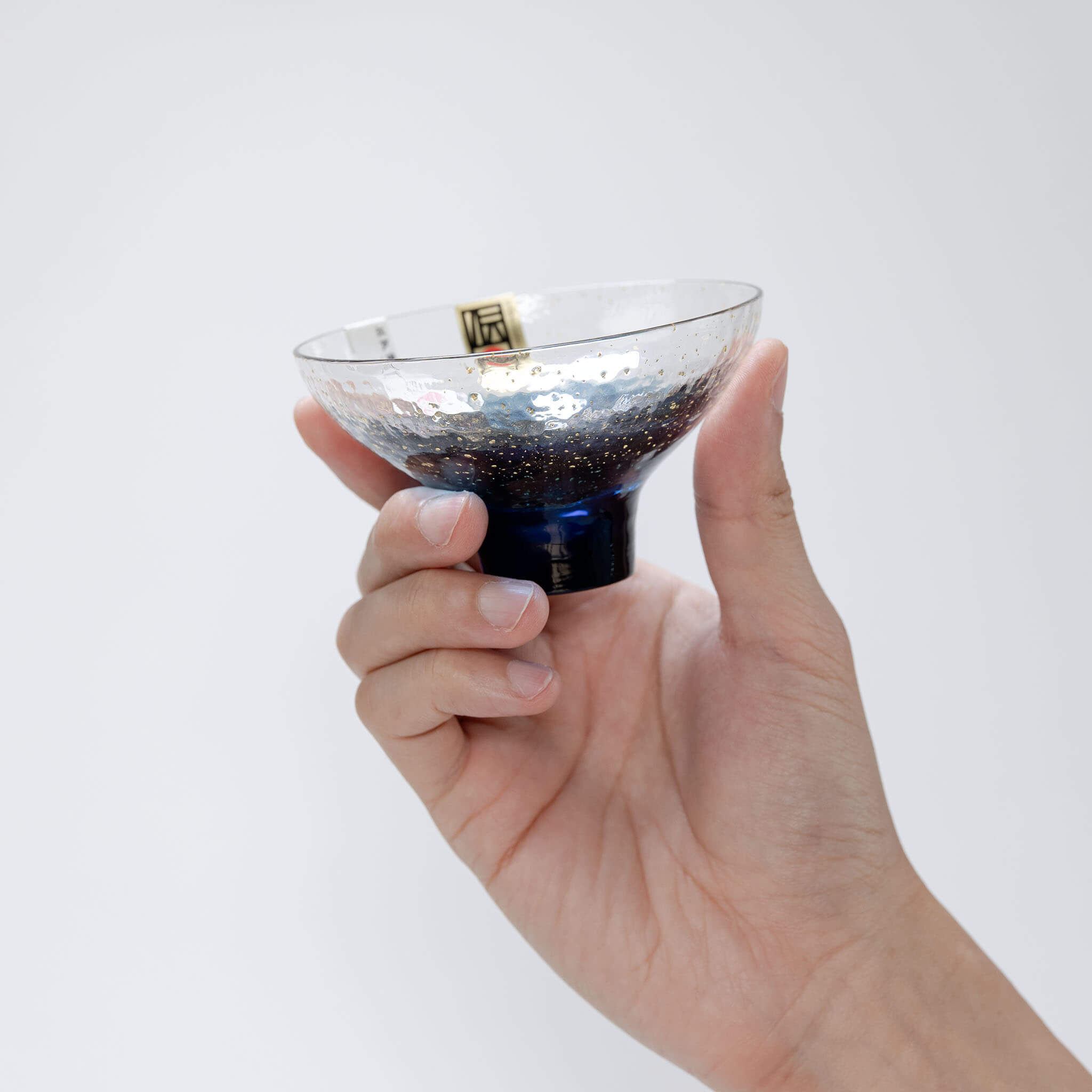 Hand holding a Toyo Sasaki Yachiyo Kiln 120ml sake cup