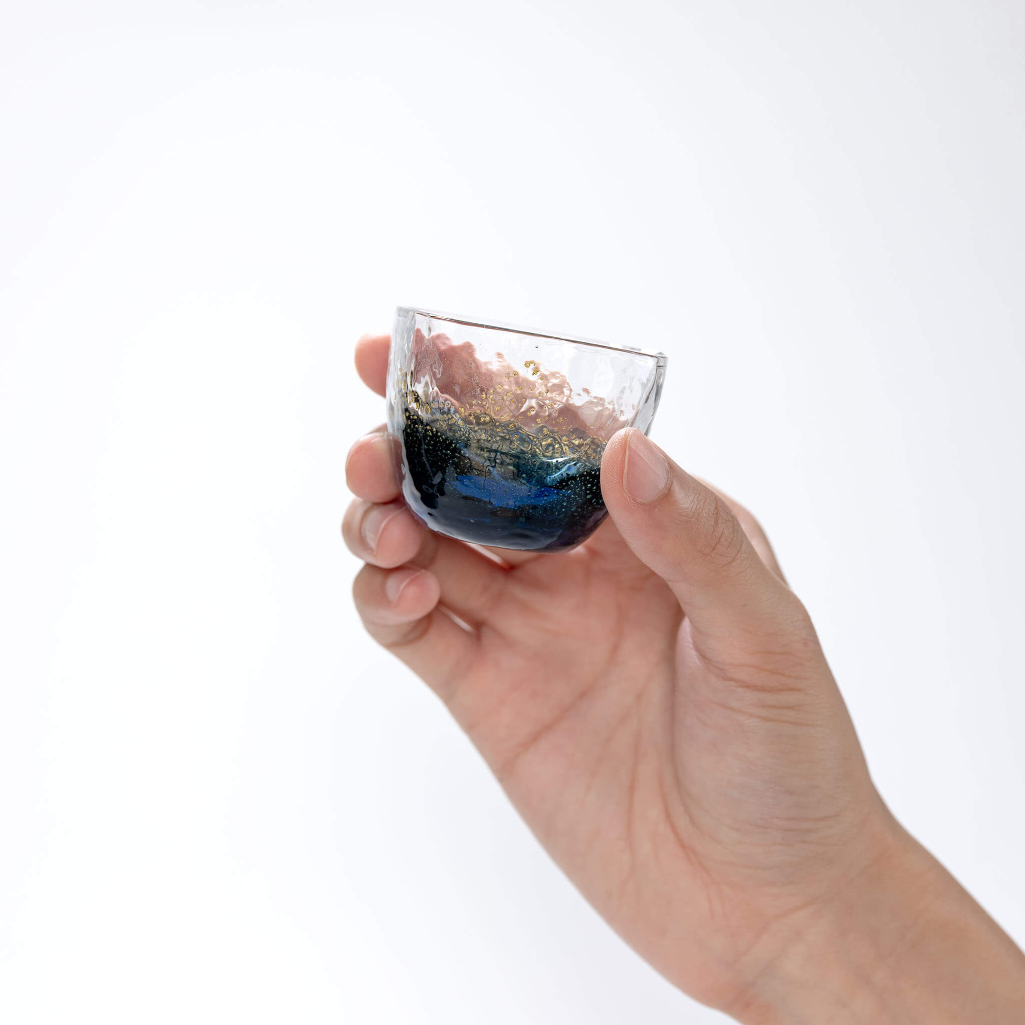 Hand holding a Toyo Sasaki Yachiyo Kiln 60ml sake glass